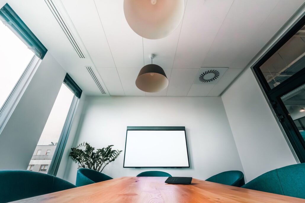 Modern conference room with a wall-mounted display and table control panel
